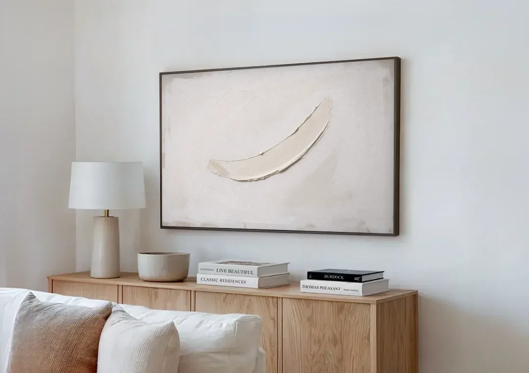 White on White Painting with a Warm Crescent canvas wall art above a wooden sideboard next to a sofa