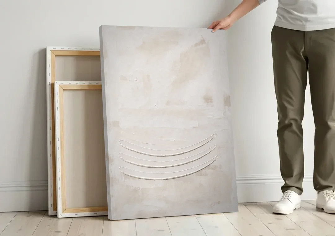 White on White Wall Art with Three Curved Ridges canvas wall art leaning against a wall next to blank canvases